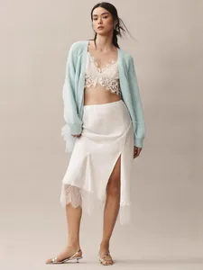 Elegant light blue knit cardigan with white lace bralette and satin slit midi skirt