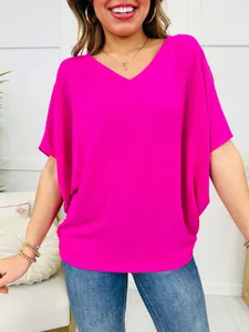Close-up detail view of a vibrant fuchsia V-neck ribbed short sleeve top on a model.