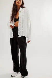 Close-up of white cotton linen blouse featuring delicate ruffle trim and long sleeves