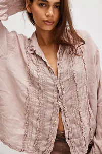 Close-up detail of mauve linen long sleeve shirt featuring delicate front ruffle trim