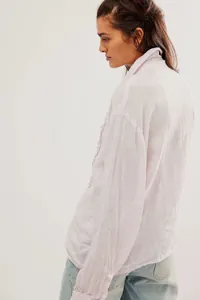Detailed side view of light lavender linen blend shirt featuring delicate front ruffle stitching
