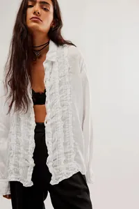 Close-up detail of white cotton linen long sleeve shirt with elegant front ruffle trim