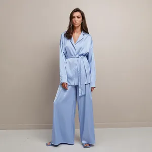 Light blue satin pajama set for women featuring wide-leg pants and belted wrap top