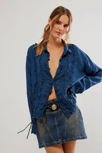Detailed macro view of blue linen long-sleeve shirt with vertical ruffle accents