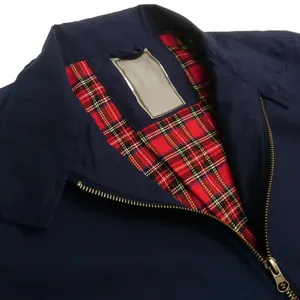 Détail d'un blouson aviateur bleu marine montrant la doublure écossaise classique.