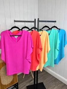 Vibrant multi-color V-neck ribbed T-shirts displayed on a black rack for summer style