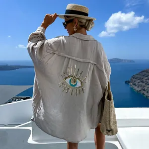 Vista dettagliata del ricamo Evil Eye con paillettes sul retro di una camicia di lino beige