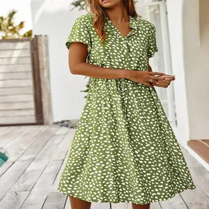 Detalle del vestido de verano verde que muestra los botones y el estampado de lunares