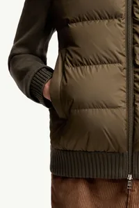 Close-up of olive green knit-paneled padded bomber jacket with zipper and pocket details.