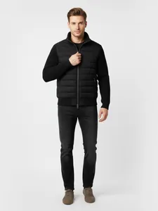 Nahaufnahme einer schwarzen Herren-Hybridjacke mit Steppfront und Strickärmeln