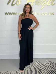 Elegant black halter neck wide leg jumpsuit for women in a stylish studio setting