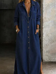 Detail of long-sleeved dark blue denim maxi dress with button-front and side slits
