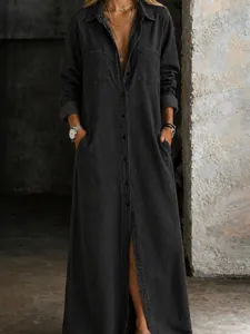 Full length washed black denim shirt dress featuring a collar and chest pockets