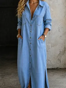 High-quality detail of a light blue denim maxi shirt dress with buttons and side slits