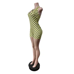 Detailansicht eines gelben Neckholder-Jumpsuits mit schwarzen Punkten und schmaler Passform