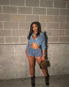 Full body view of a woman wearing a two-piece denim set with cropped jacket and shorts