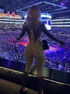 Vista posteriore dettagliata di una tuta gialla a pois con scollo all'americana allo stadio.