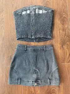 Detailansicht eines grauen Denim-Sets mit Top und Reißverschluss sowie Minirock.