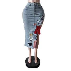 Dettaglio di gonna midi in denim a vita alta con vivaci toppe ricamate.