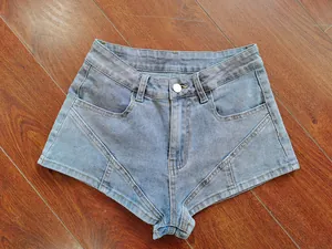 Detail view of light blue denim shorts with unique V-shaped stitched panels