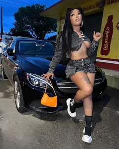 Fashion model posing in a grey denim jacket and mini skirt set with large pockets