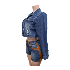 Side view detail of a cropped denim jacket and shorts set with brown leather accents.