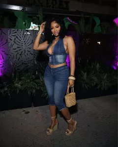 Vista completa di un sexy set top halter in denim e pantaloni capri di notte.
