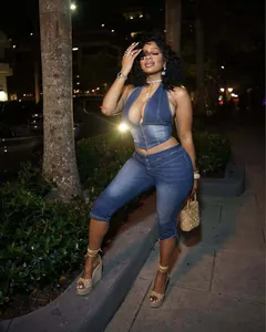 Dettaglio di un top halter in denim e pantaloni capri coordinati su una modella.