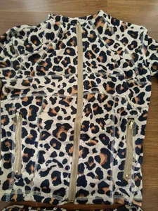 Gedetailleerd overzicht van de luipaardprint hoodie met gouden ritsen en stiksels