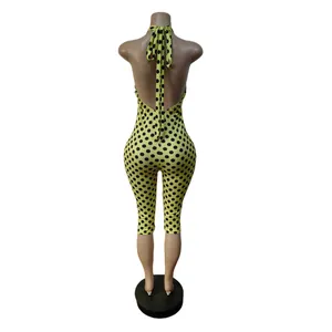 Vista posteriore di una tuta aderente gialla a pois con scollo all'americana per donna