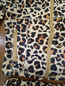 Detail van sportief damesjack met luipaardprint, ritssluiting en contrasterende stiksels