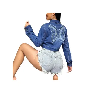 Fashionable women's cropped blue denim jacket featuring a large embroidered butterfly on back