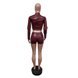 Rückansicht eines weinroten PU-Leder-Zweiteilers mit Crop-Top und engen kurzen Shorts
