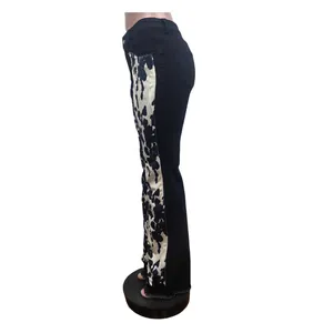 Seitenansicht schwarzer Schlagjeans mit Kuhprint-Einsatz und FransenSaum.