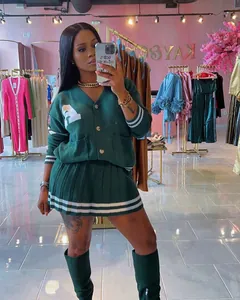 Detailed view of a stylish two-piece dark green knit cardigan and pleated skirt set