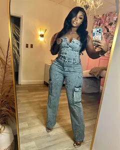 Detailed view of strapless denim jumpsuit featuring unique cross embroidery patches
