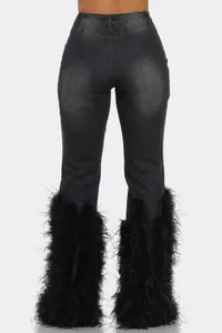 Back view of distressed black denim jeans featuring luxurious black feather trim cuffs.