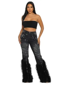Detailed view of high stretch distressed black jeans with pearl and feather trim decoration.