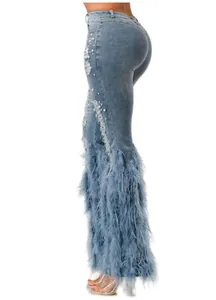 Close-up of light blue distressed jeans with pearl accents and blue feather hem.