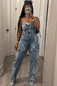 Strapless blue denim jumpsuit featuring unique cross patch embroidery and cargo pockets