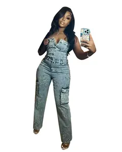 Detail view of a strapless denim jumpsuit featuring distinctive cross embroidery and pockets.