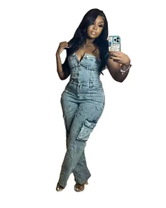 Detailed view of the strapless denim jumpsuit featuring vintage cross embroidery patches
