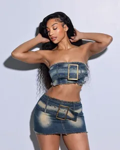 Detail view of denim two-piece set with tube top and skirt featuring large buckles