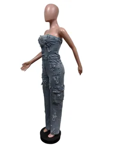 Side view of a strapless denim jumpsuit with distressed cross patches and cargo pockets.