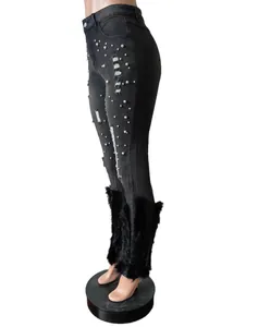 Black distressed denim jeans with pearl embellishments and faux fur trim at the cuffs