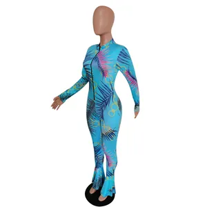 Detail of slim fit blue jumpsuit featuring tropical palm leaf and chain print