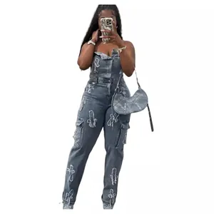 Trendy strapless denim jumpsuit with distressed cross patches, cargo pockets and a slim fit.