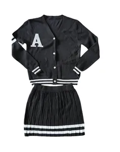 Two-piece black knit cardigan and pleated skirt set featuring white varsity stripe details