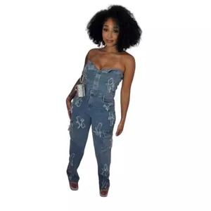 Full body view of a slim fit strapless denim jumpsuit featuring unique cross embroidery