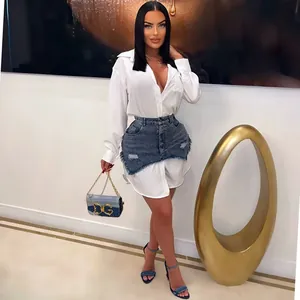 Modell zeigt ein weißes Langarm-Hemdkleid mit einem Distressed-Denim-Rock-Overlay